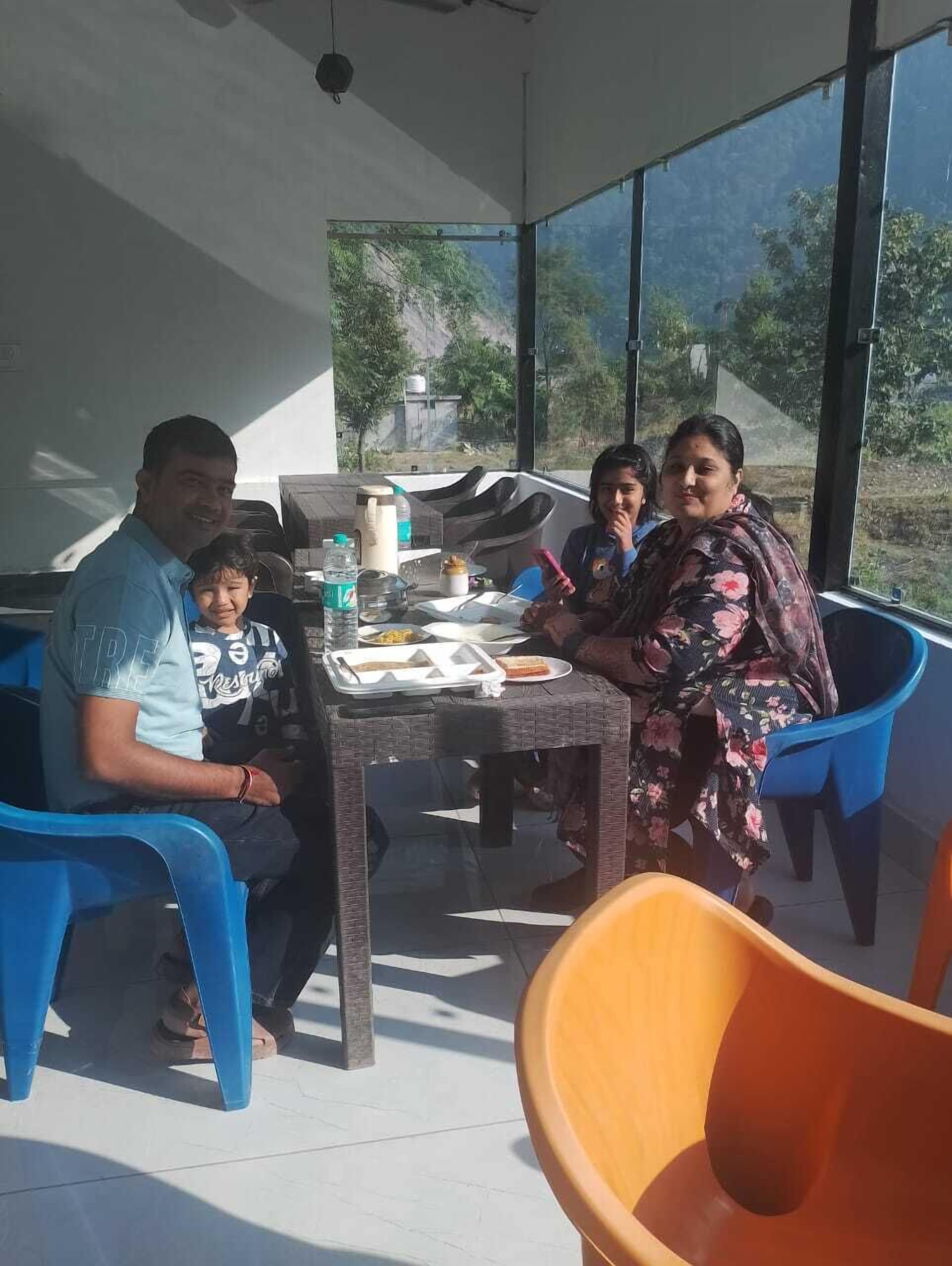 A family dining at a table with a view of greenery outside.