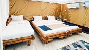 A room with two beds, a mosquito net, and an air conditioning unit. - Camp Aquaforest  (Rishikesh)