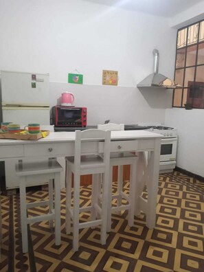 Een koelkast met diepvriezer, een oven, een kookplaat