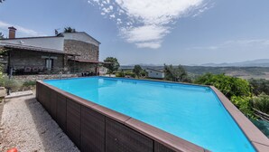 A rectangular swimming pool with a stone house in the background. - Villa Paradiso - Irpinia (Gesualdo)