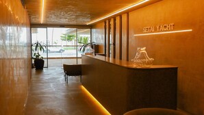 Un área de recepción de diseño moderno, con mostrador de recepción, asientos y vistas al exterior.