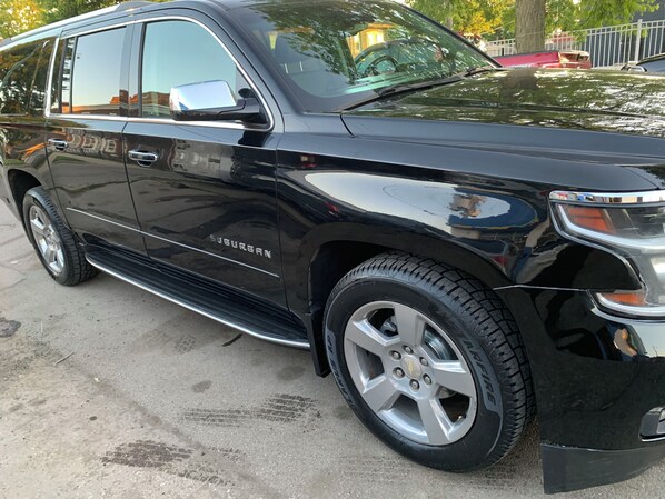 Ein schwarzer SUV steht auf einer Betonfläche.