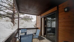 A covered outdoor area with a table and chairs, a wooden deck, and a view of a snowy landscape. - Pinetree Retreat - Hot Tub, Heated Pool & Sauna - 6 Min Walk to Dining & Lift (Park City)