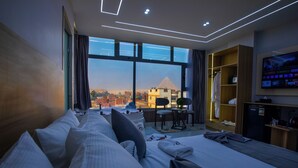 A modern hotel room with a large bed, a desk, and a TV. - Royal Pyramids View Inn (Giza)