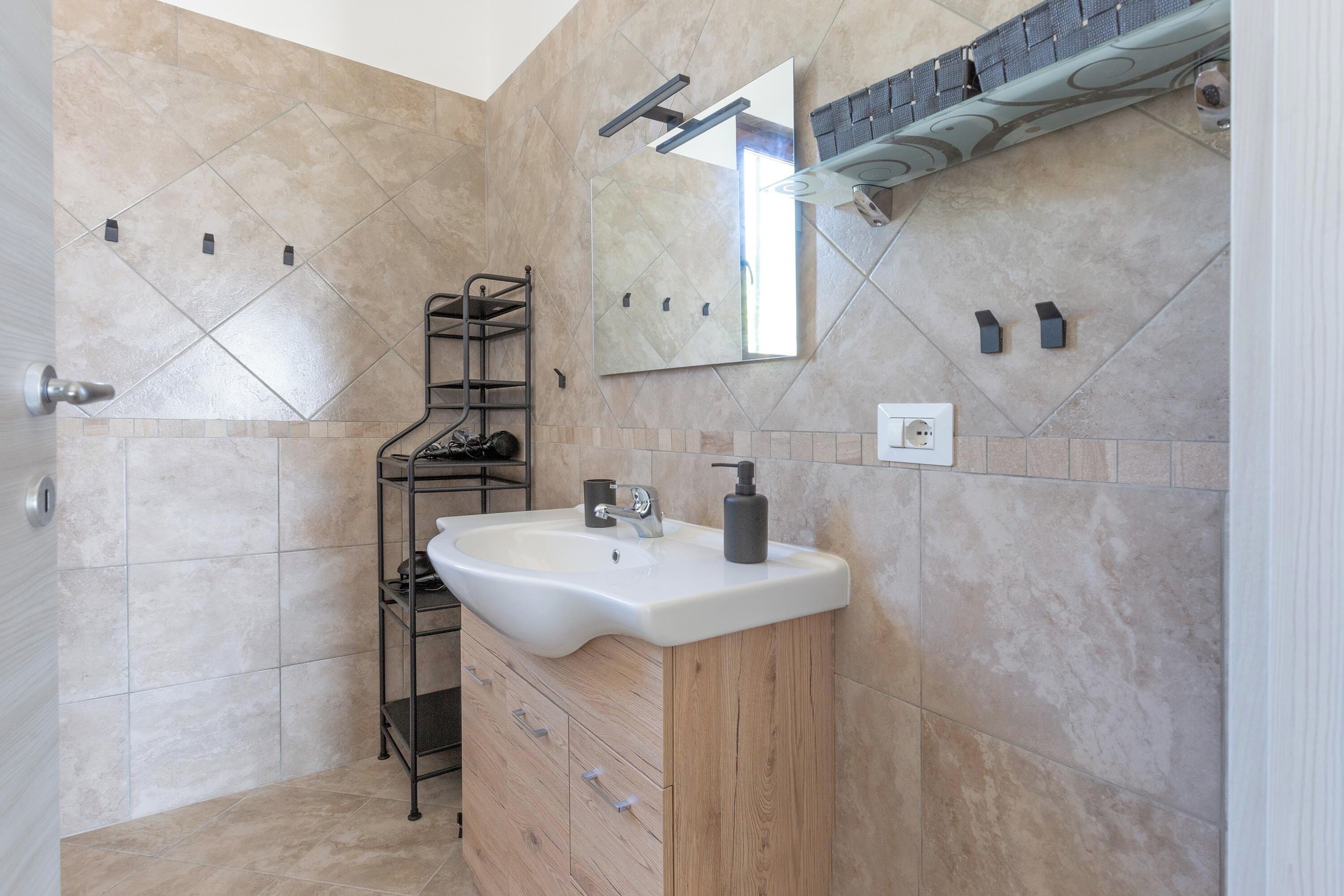 Ein Badezimmer mit Waschbecken, Spiegel und Handtuchhalter.