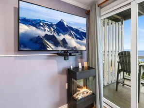 A television mounted on a wall, a fireplace, and a balcony with a chair. - ML288 New Deck Great Views EZ Parking WiFi Retreat (Snowshoe)