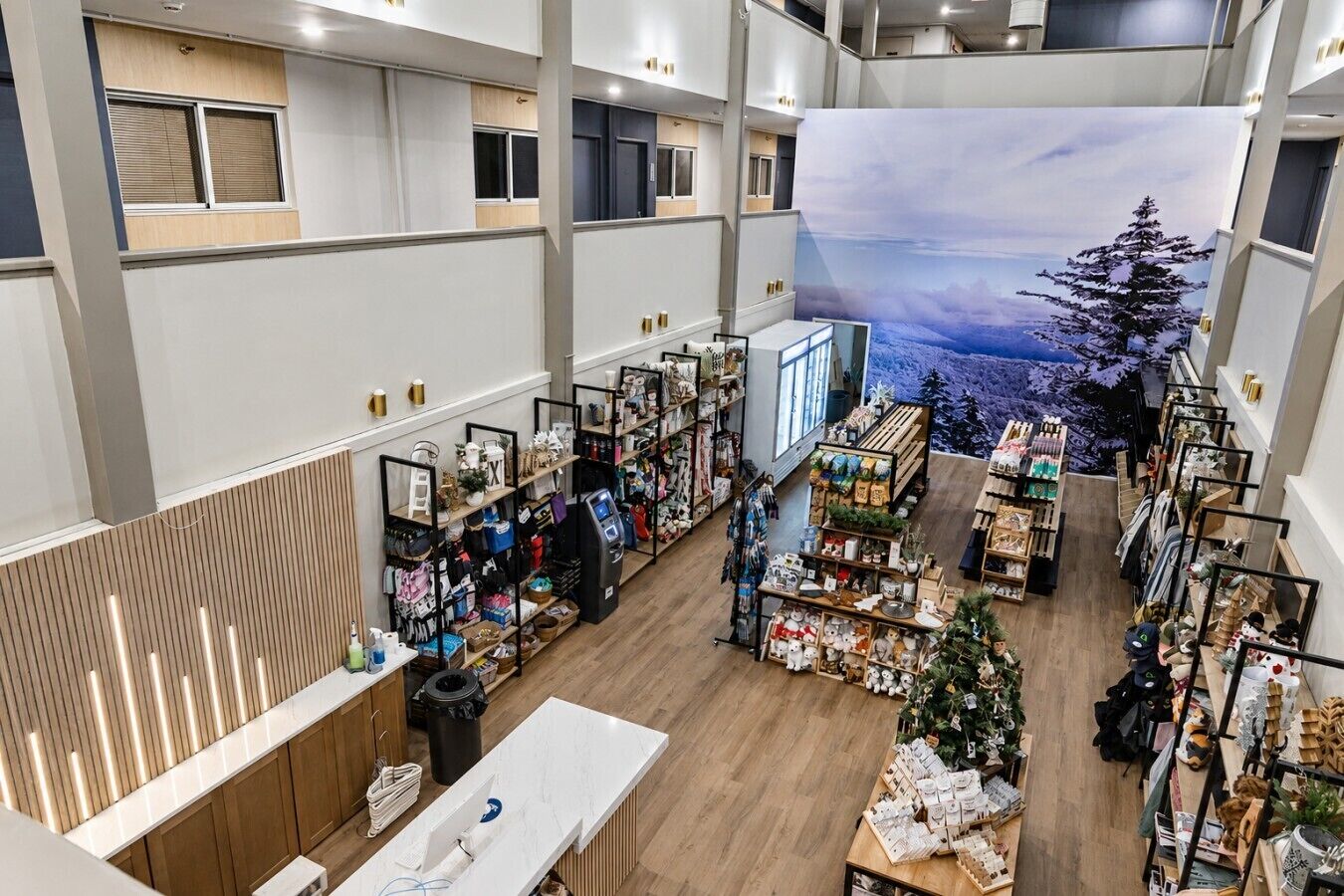 A spacious retail area with multiple aisles, a central display table, and a large mural on the back wall.