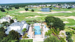 A golf course with a swimming pool and lounge area surrounded by palm trees and houses. - RR796DRC - Perfect Getaway in Reunion for up to 6 guest (Kissimmee)