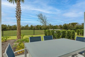 An outdoor patio with a table and chairs, surrounded by greenery and a fence. - RR796DRC - Perfect Getaway in Reunion for up to 6 guest (Kissimmee)