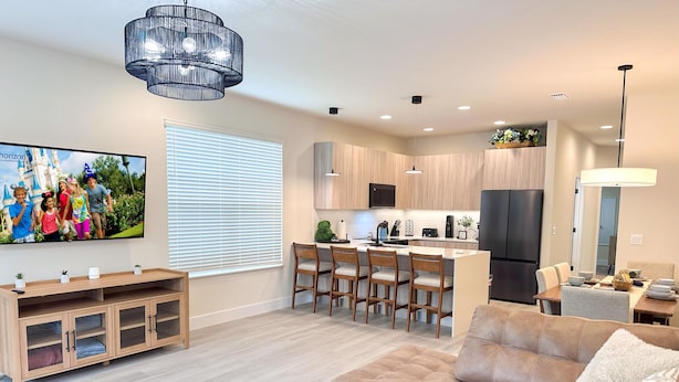 Un salon moderne avec un canapé, une table basse et un téléviseur fixé au mur.