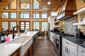 Enjoy cooking in this well-equipped kitchen with a central island, sink, stove, and ample counter space.