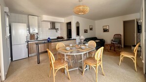 Una cocina moderna con armarios blancos, estufa integrada y una lámpara colgante.