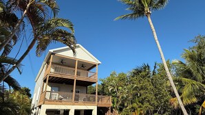 A two-story beachfront house with a balcony and a covered porch. - Hibiscus House - Heated Pool (Big Pine Key)
