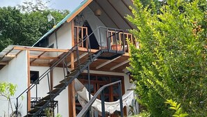 Ein zweistöckiges Gebäude mit einer Holztreppe, die zu einem Balkon führt.