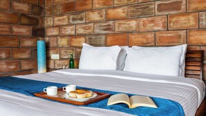 A neatly made bed with a blue blanket, a tray with muffins and cups, and an open book on the bed. - Lazy Hills by Xplore Indo (Kotagiri)