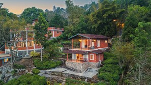 A hillside property with multiple brick houses, stone pathways, and lush greenery. - Lazy Hills by Xplore Indo (Kotagiri)