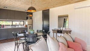 A modern kitchen with a dining area, wooden ceiling, and a large mirror. - Modern House near the Beach (Punta Ballena)