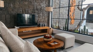 Relax in this stylish living room with a flat-screen TV, comfortable sofa, and a view of the cactus garden.