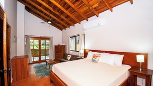 A bedroom with a wooden ceiling, a large bed, a nightstand, a dresser, and a window with curtains. - 3 min walk to surf, 3bedrooms, Villa, Pool, Steps to the Beach! (Uvita)
