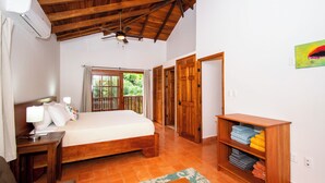A bedroom with a wooden ceiling, a bed, a nightstand, a bookshelf, and a window with curtains. - 3 min walk to surf, 3bedrooms, Villa, Pool, Steps to the Beach! (Uvita)