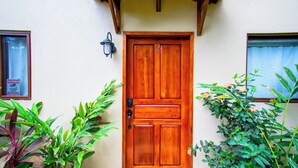 A wooden door with a number 2, a wall-mounted light, and potted plants on either side. - 3 min walk to surf, 3bedrooms, Villa, Pool, Steps to the Beach! (Uvita)