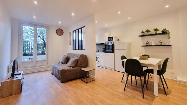Un apartamento moderno con sala de estar, kitchenette y comedor.