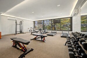 A gym with treadmills, stationary bikes, a bench press, and dumbbells. - Lux 1BR w/ Rooftop Pool, Close to Beach (Tulum)