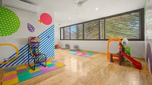 A room with a basketball hoop, play mats, and a slide. - Lux 1BR w/ Rooftop Pool, Close to Beach (Tulum)
