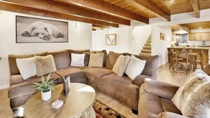 Ein gemütliches Wohnzimmer mit einer Eckcouch, einem Couchtisch und einem gerahmten Bild an der Wand.