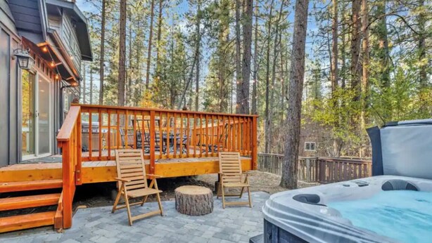 Eine Holzterrasse mit Sitzgelegenheiten und einem Whirlpool.
