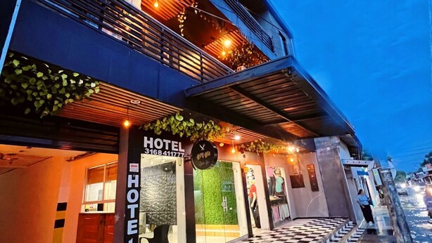 Un hôtel avec un sol à carreaux à l’extérieur, une entrée bien visible et une enseigne.