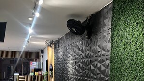 Un espace d’accueil moderne, agrémenté d’un mur au motif géométrique, d’un jardin vertical verdoyant et d’un coin salon avec deux canapés.