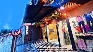 Un hôtel avec un sol à carreaux, une entrée bien visible et une enseigne indiquant la présence d’un restaurant.
