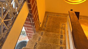 A staircase with patterned tiles and metal railings.