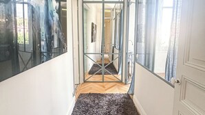 Um corredor com carpete preto, portas de vidro e piso de madeira.