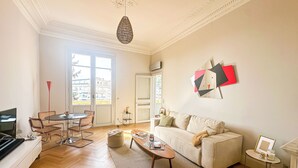 Uma sala de estar moderna com sofá, mesa de centro e área de jantar.