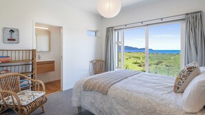 Une chambre dotée d’une grande fenêtre donnant sur la campagne.