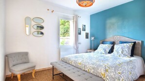 Ein Schlafzimmer mit einem Bett, einer Bank, einem Stuhl und Wandspiegeln.