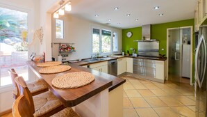 Una cocina moderna con una isla de madera, electrodomésticos de acero inoxidable y una pared de acento verde.