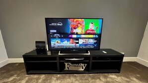 Un televisor de pantalla plana sobre un soporte negro con un logotipo de 'Family', mostrando una interfaz de Disney+ con diversas series y películas.