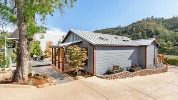 A single-story building with a garage, a covered porch, and a landscaped front yard.