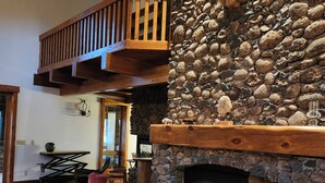 A cozy living room with a stone fireplace, wooden furniture, and a deer head mounted on the wall. - Charming unique 2-bdrm farmhouse in Mesa with WiFi, close to Powderhorn Ski Area (Mesa)