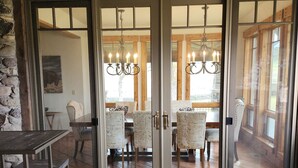 A rustic interior with wooden beams, a stone wall, and a dining area with a chandelier. - Charming unique 2-bdrm farmhouse in Mesa with WiFi, close to Powderhorn Ski Area (Mesa)