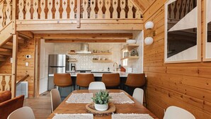 Un intérieur en bois comprenant un coin repas, une cuisine et un escalier.