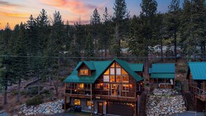 A cabin with a green roof, wooden structure, and a stone foundation. - Denton by Avantstay Hot Tub, Deck w/ Fire Pit Near Skiing & Lake! (Truckee)