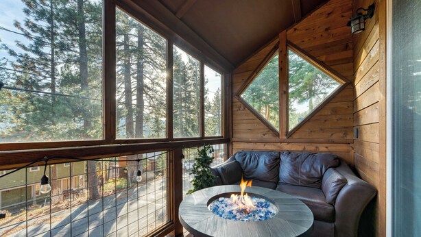 A cozy cabin with a wooden interior, a fire pit table, and a leather sofa. - Denton by Avantstay Hot Tub, Deck w/ Fire Pit Near Skiing & Lake! (Truckee)