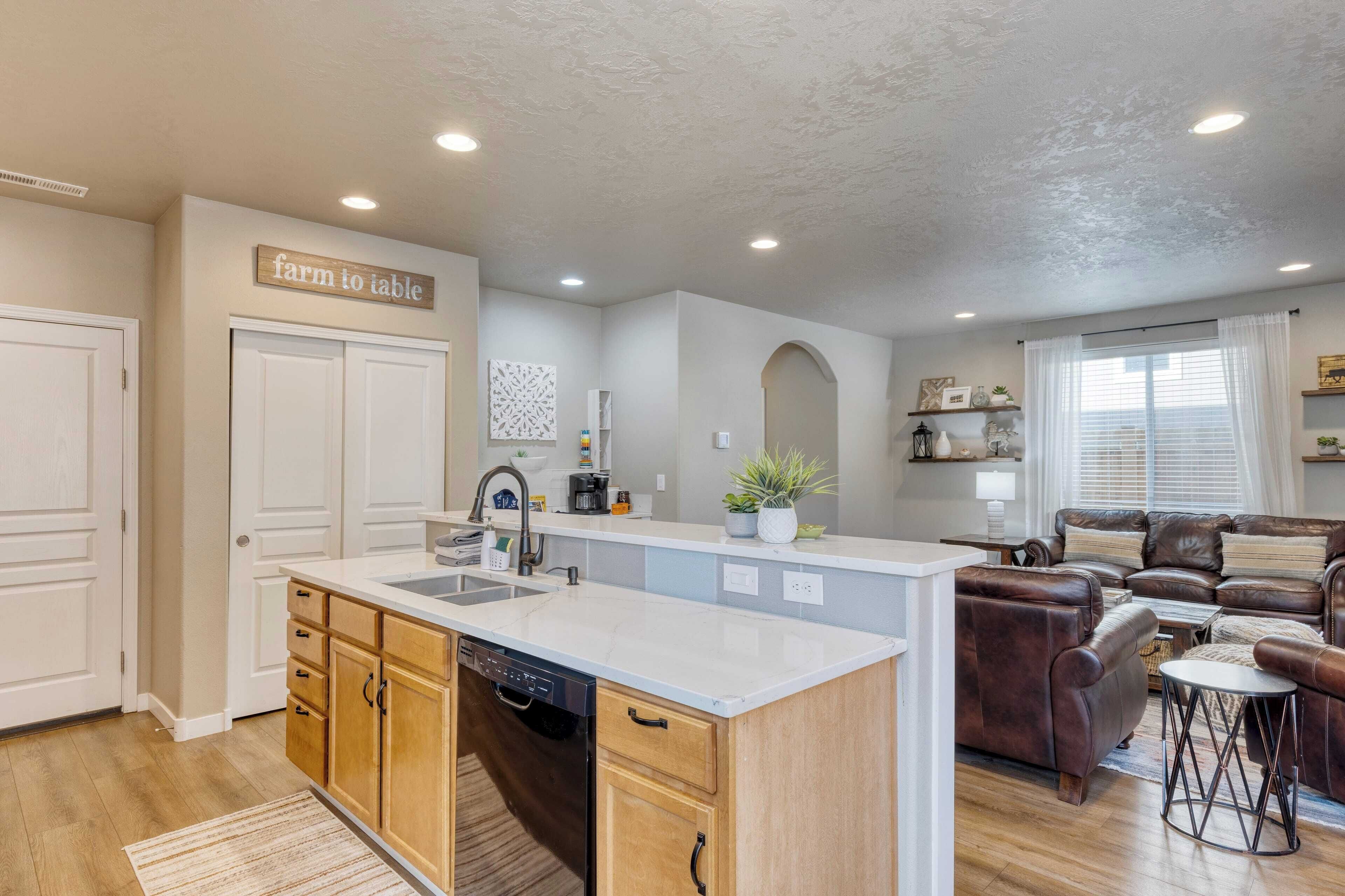 A modern kitchen with a farmhouse sign, wooden cabinets, and a dishwasher.