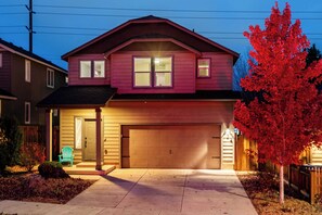 A two-story house with a garage, a front porch, and a red-leaved tree. - Old Mill Getaway by Avantstay Private Backyard w/ Hot Tub (Bend)