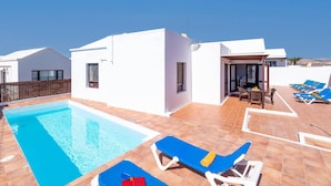 Une villa moderne dotée d’une piscine, d’un espace extérieur aménagé et offrant une vue sur le paysage.