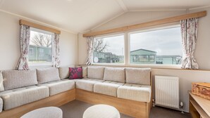 A cozy room with a large window, a sofa, and a small table.